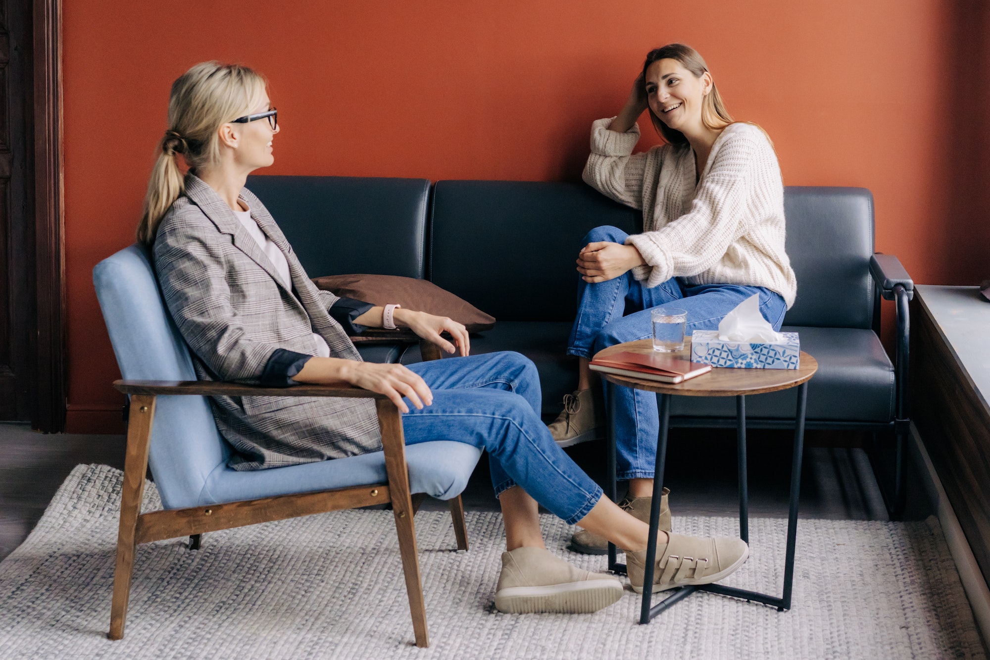 Relaxed young woman talking with therapist in a cozy office.