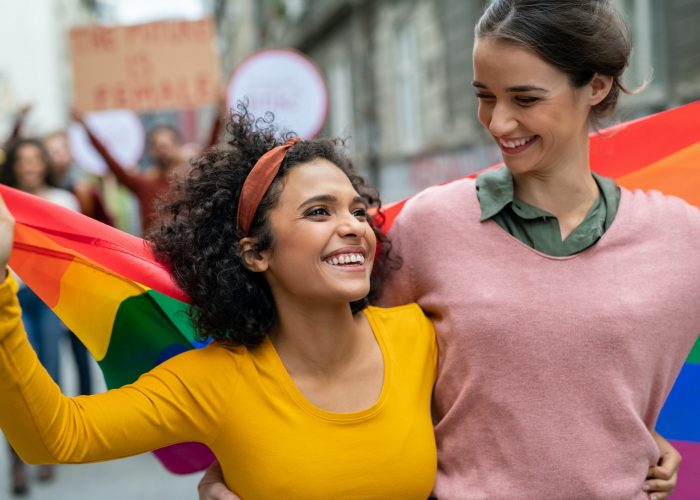 Lesbian couple at gay pride with rainbow flag